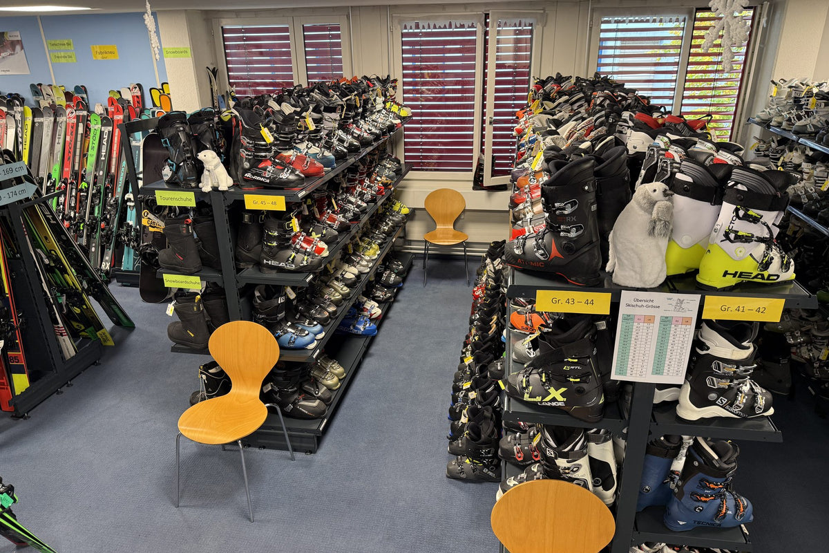 Regale mit Skischuhen nach Grösse sortiert und Ski im Showroom von Ski Stepan